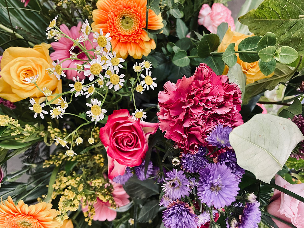 Bunter Blumenschmuck aus verschiedenen Blumen bei einer Beisetzung