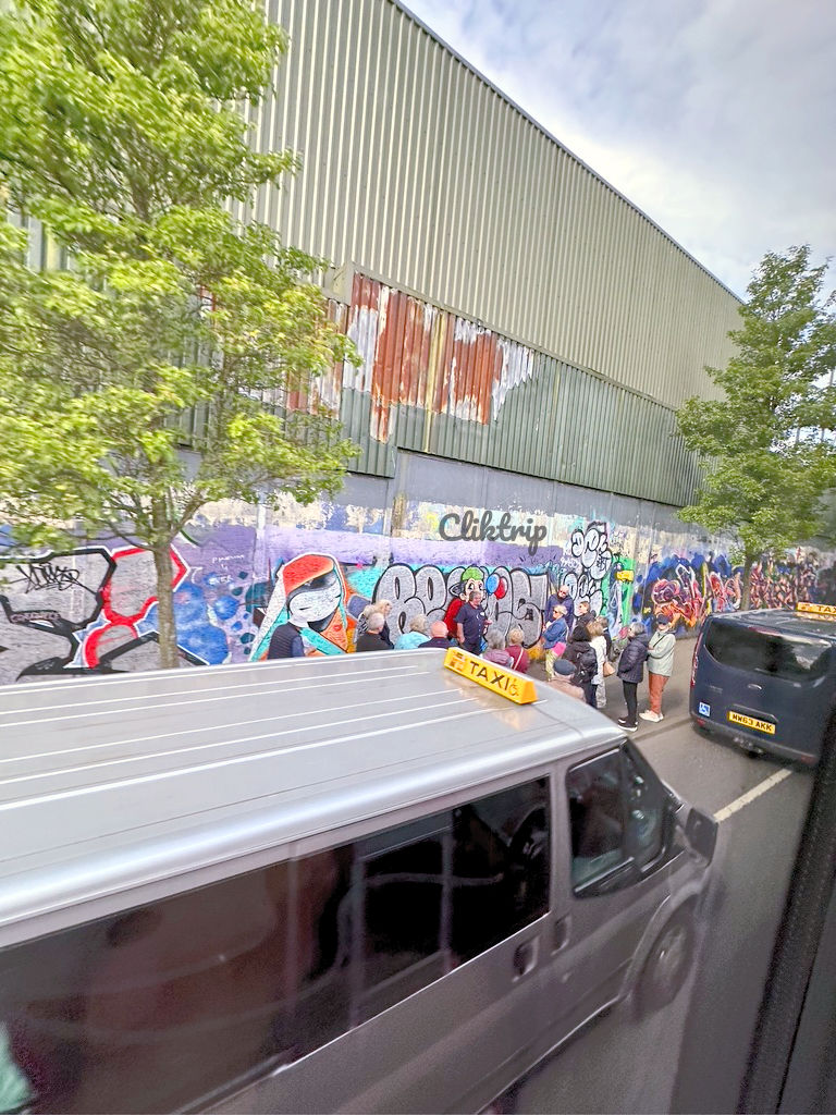 Táxis que fazem o tour guiado; Atrás desse enorme muro está um dos bairros protestante.