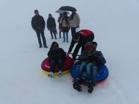 Indische Touristen haben Spaß mit den Snow-Tubes