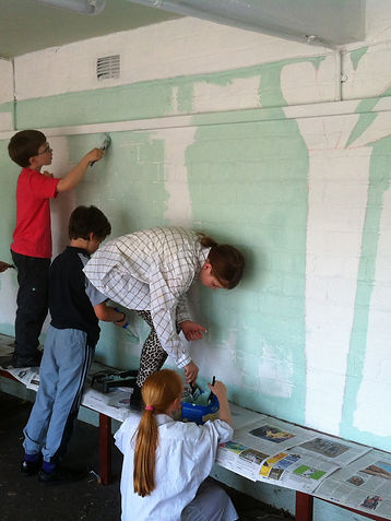 children painting a mural on a wall