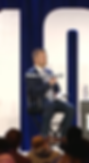 Man in a suit speaking on stage for an Evy Media case study