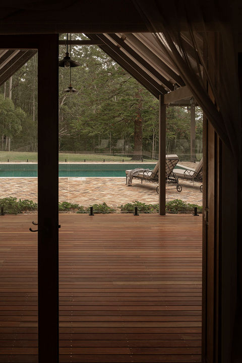 Looking out from the timber decking underneat the cabana towards the peaceful luxury pool