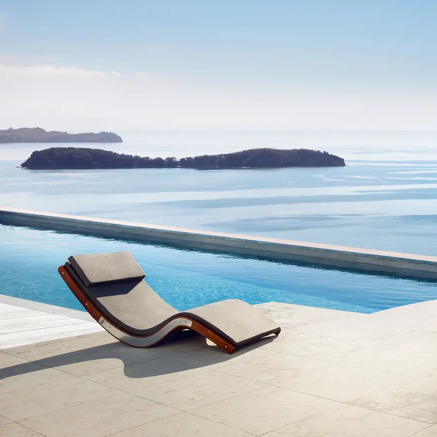 The stunning curved design of the sun lounger stands out from the sharp edges of the concrete pool