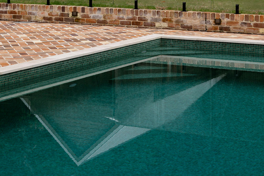 Luxury Pool with mosaic tiles reflecting the surrounding ladnscaping.