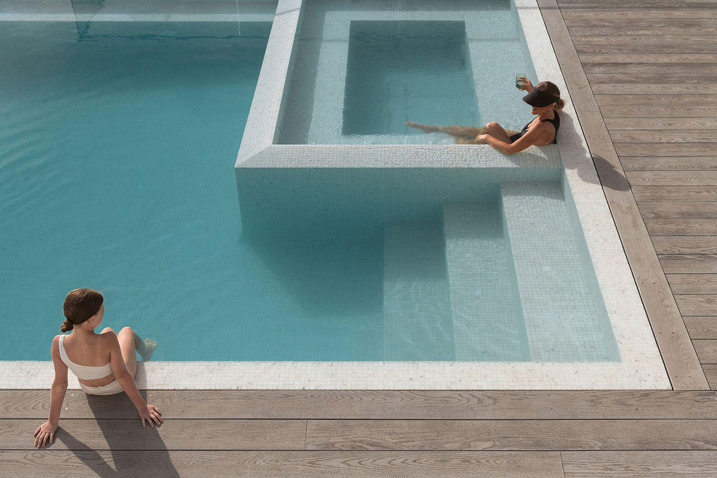 Fully tiled perimeter edge spill over concrete pool and spa with Millwood decking | Design and build by Luxury Pools & Outdoor Living