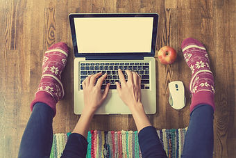 Woman's hands typing on laptop keyboard.