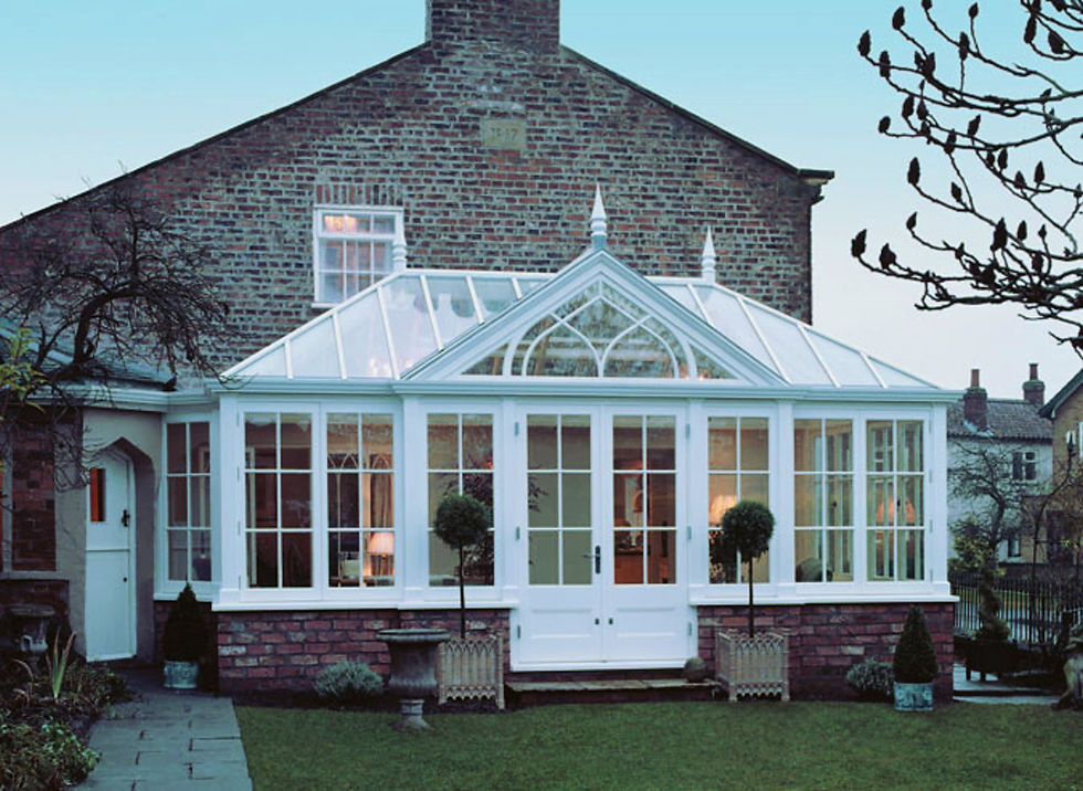 White painted timber gable-fronted conservatory with French doors on a brick dwarf wall