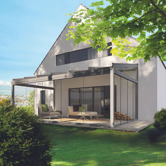 Weinor glass room installed at the rear of a modern house beside the garden