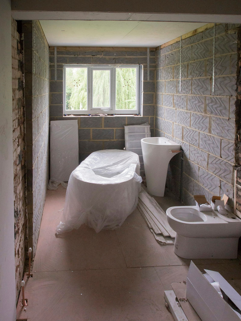 Bathroom mid-refit with blockwork walls, a wrapped bath and new sanitaryware
