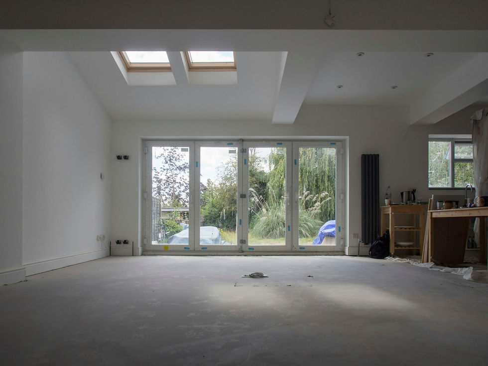 Open-plan rear extension with a boxed-in downstand beam across the ceiling, rooflights and bifold doors