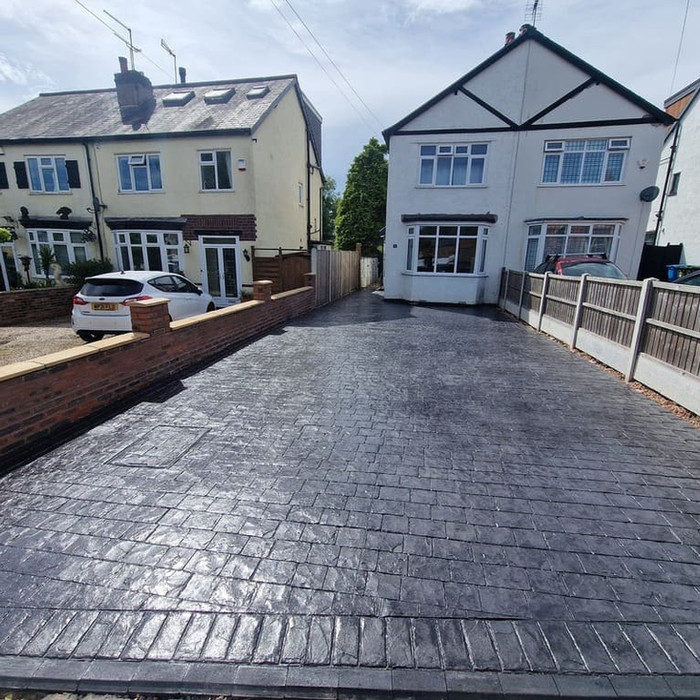 Long pattern imprinted concrete driveway in slate grey.