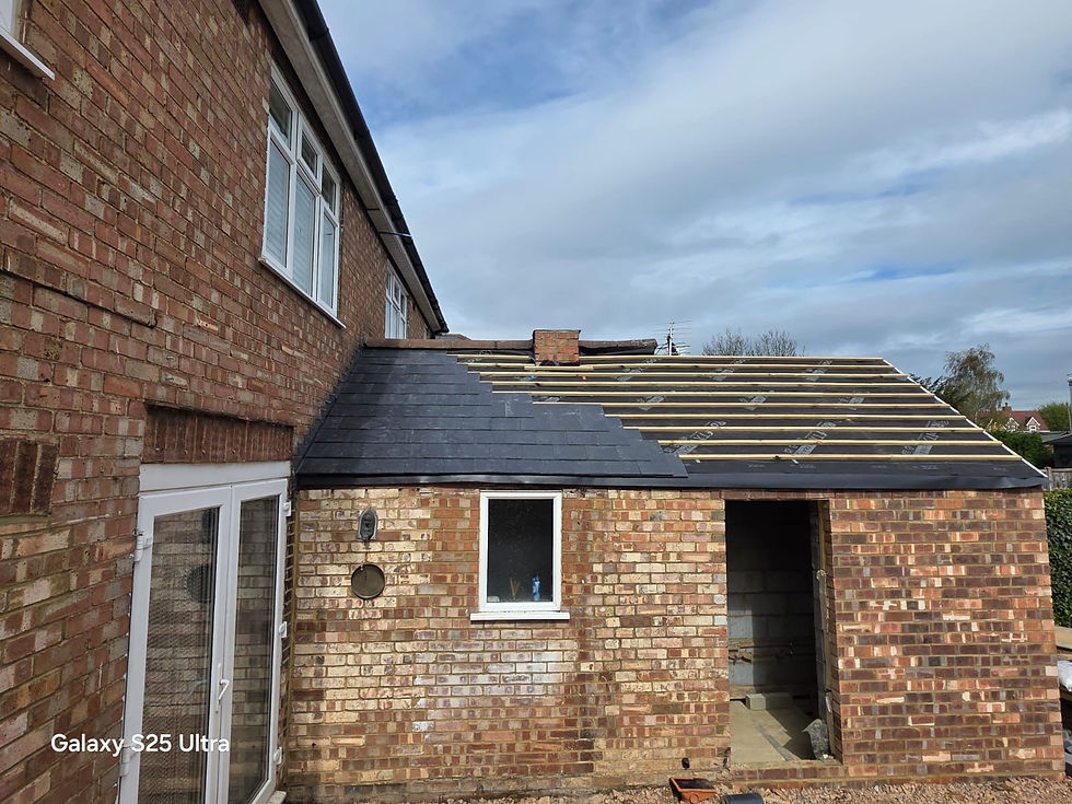 Single-storey extension roof being tiled with one window fitted