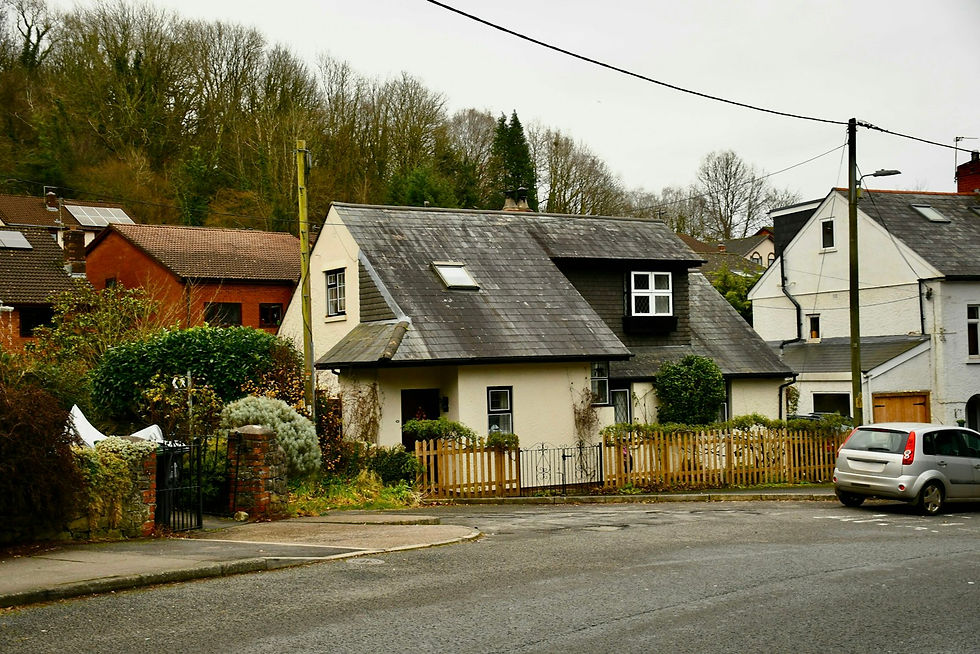 Rendered house with a dormer window and rooflights on a slate roof