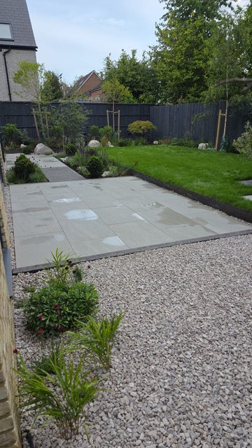 A large patio that anchors the garden in our Waltham Cross New Build project
