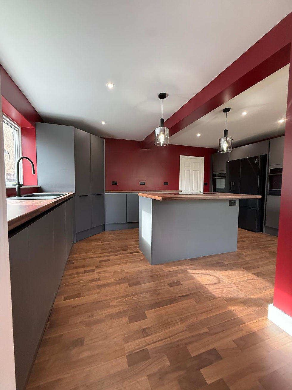 Grey kitchen with an island, pendant lights and tall oven housing