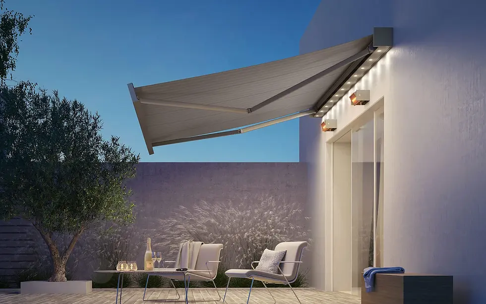 Retractable cassette awning with integrated LED lighting extended over a patio seating area at dusk