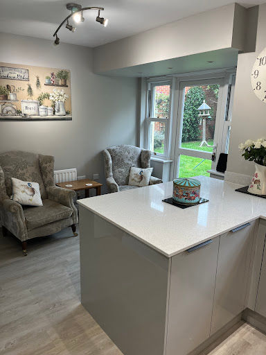 Kitchen peninsula looking into a sitting area with armchairs
