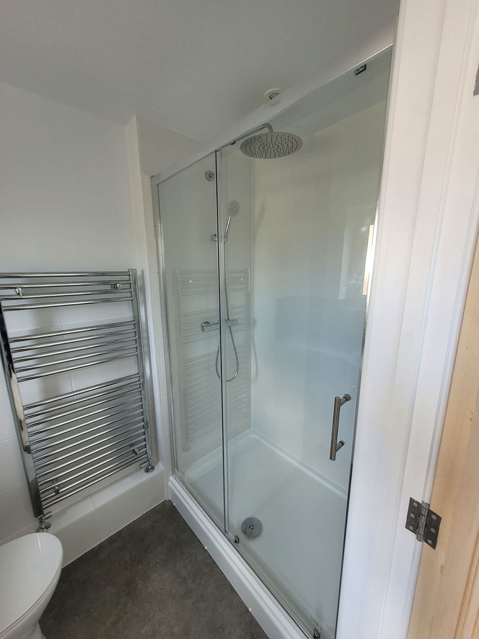 Walk-in shower enclosure with a chrome heated towel rail