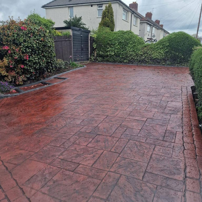 Red pattern imprinted driveway with block paving effect.