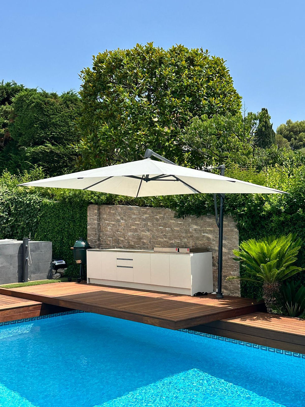 Single white outdoor kitchen unit on a timber pool deck, shaded by a large cream cantilever parasol
