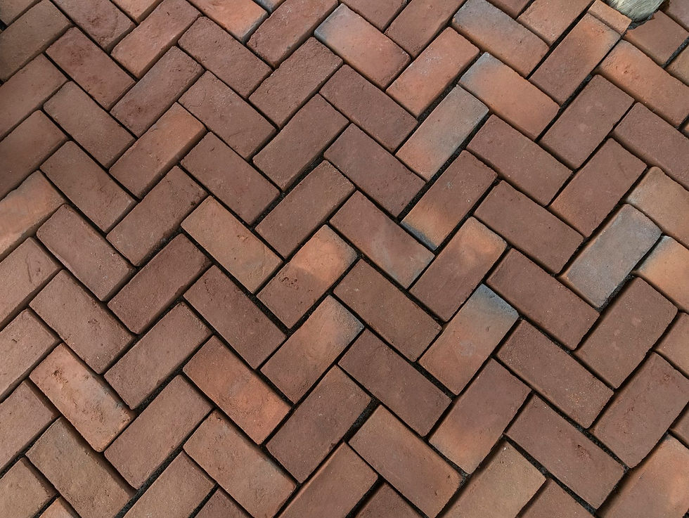 Brown clay block paving laid in a herringbone pattern