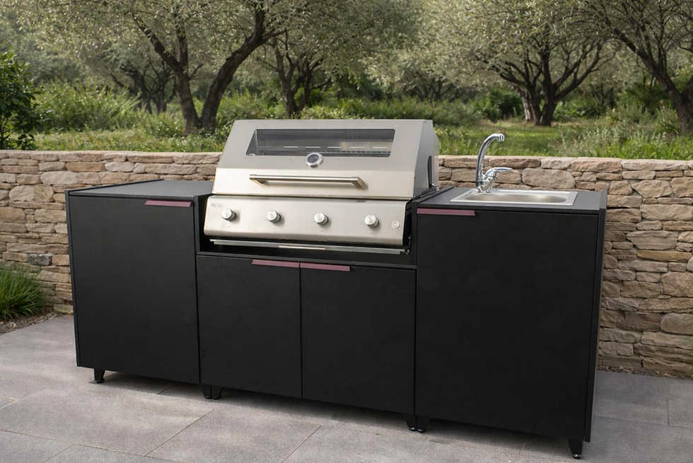 Black modular outdoor kitchen with a stainless barbecue and sink unit against a dry-stone wall