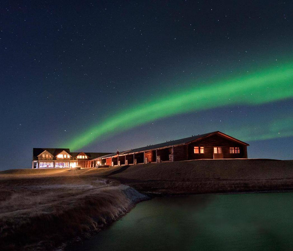 the northern lights streak across the sky above the eco hotel in Iceland Hotel Ranga