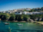 A view of Cornwall and the bay below with boats bobbing in the harbour