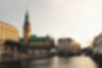 A view of Hamburg at sunrise with the sun glinting off the regal buildings