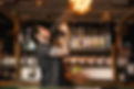 Bartender spraying fire from a bottle behind a bar