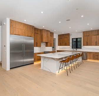 Kitchen showroom featuring custom wood cabinetry and stone countertops