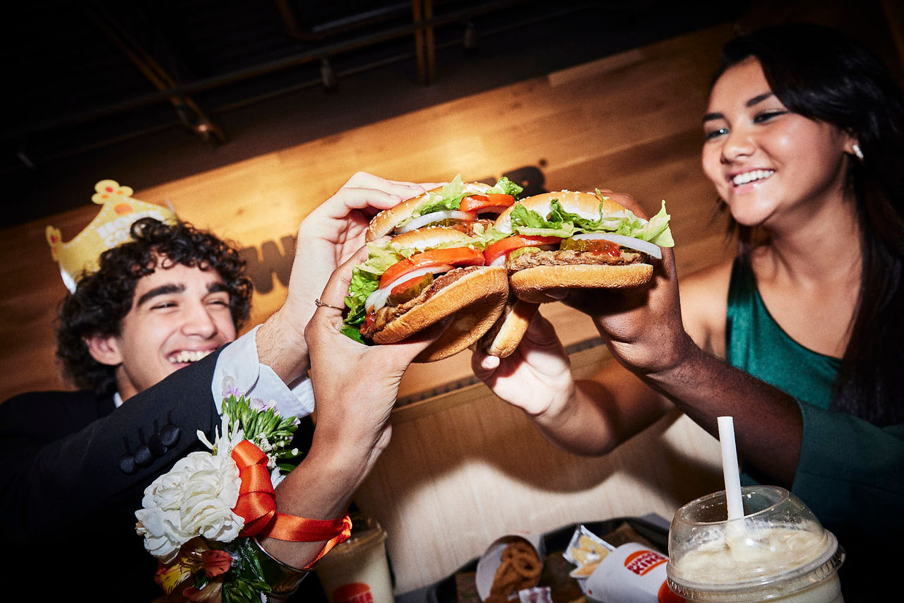 friend toasting with burgers