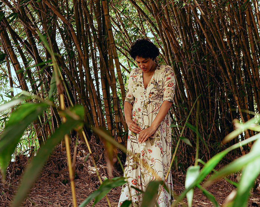 Pregnant woman in white among the bamboo.