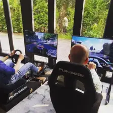 Racing simulator game rental setup with large screen for private event