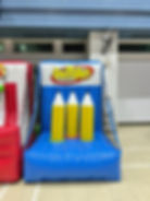 A vibrant inflatable ring toss game setup with multiple targets and oversized rings, designed for players of all ages