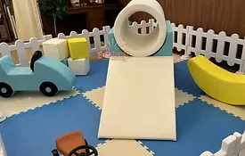 Pastel blue and white soft play rental with tunnel, foam car and banana rocker
