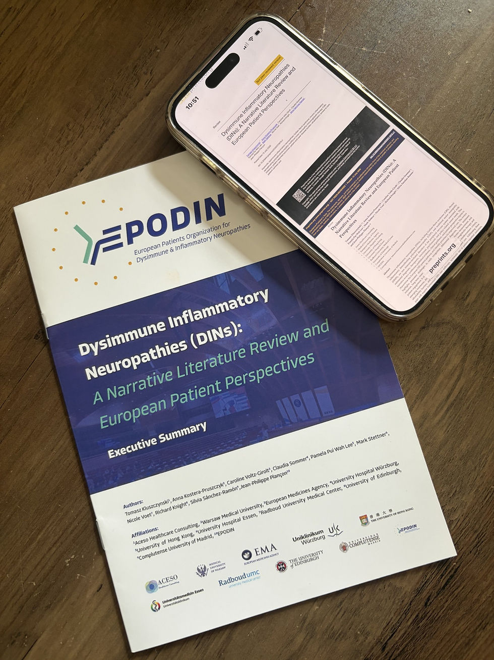 A picture of the DIN White Paper Executive Summary and a mobile phone with the report loaded on it