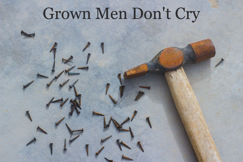 A rusty hammer and nails on a storm-colored surface