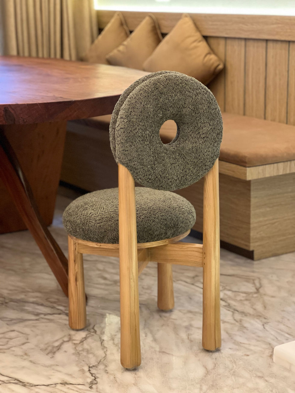 Unique chair with circular backrest and wooden legs.