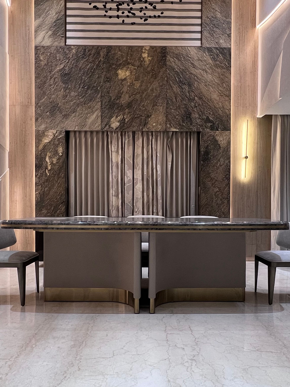 Luxurious dining area with marble wall and table.