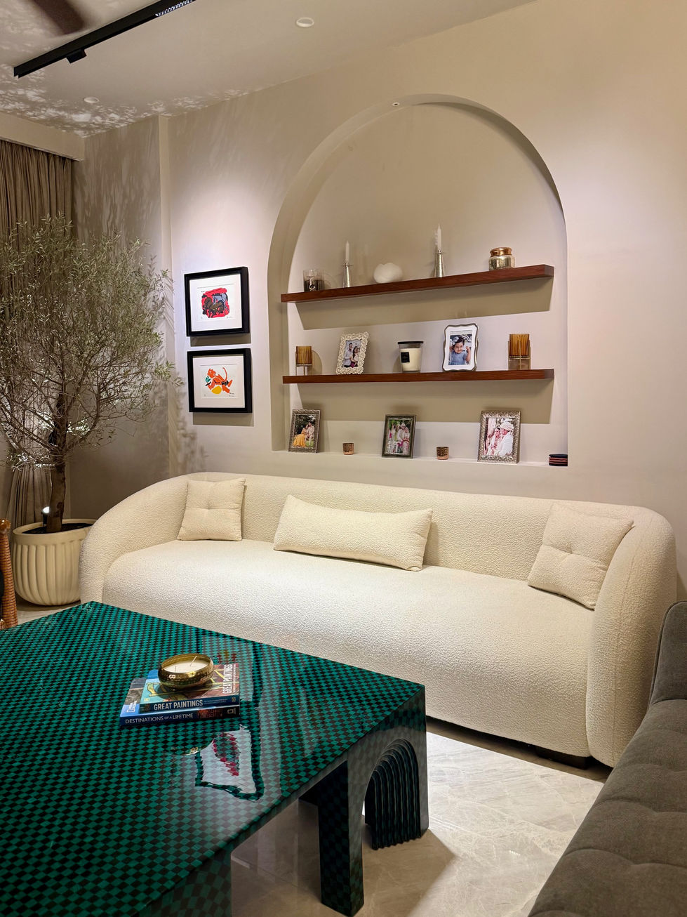 Elegant living room with white sofa and wall shelves.