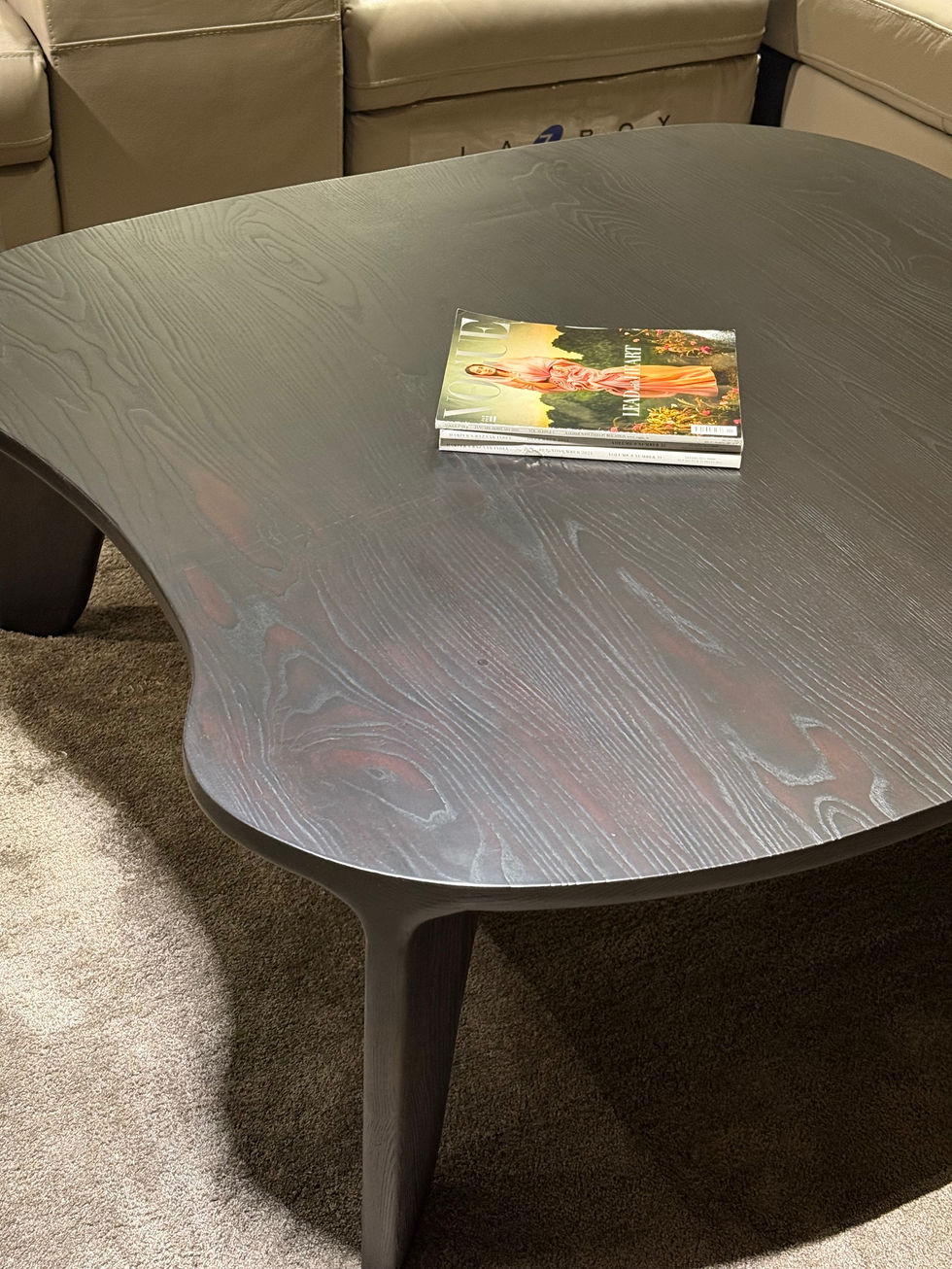 Curved wooden table with a book on top.