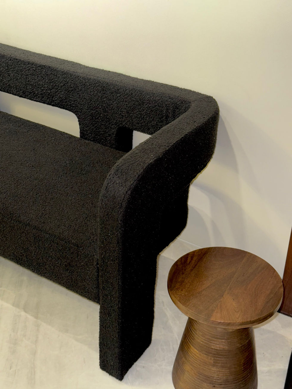 Black textured chair beside small wooden table.