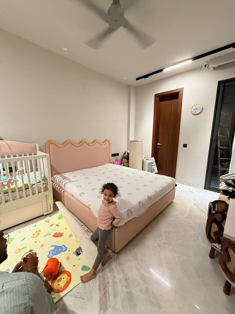 Child smiling in a cozy bedroom setting.