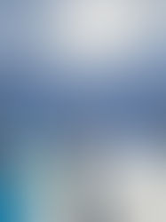 School skiers in colourful outfits stand on a snowy slope under a bright sun, with majestic mountains on Passo Tonale in the background.