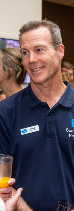 Smiling guest in a navy polo shirt networking at the Allied Health Excellence Awards 2026 in Canberra
