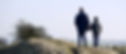 man and boy walking on grass near fence_