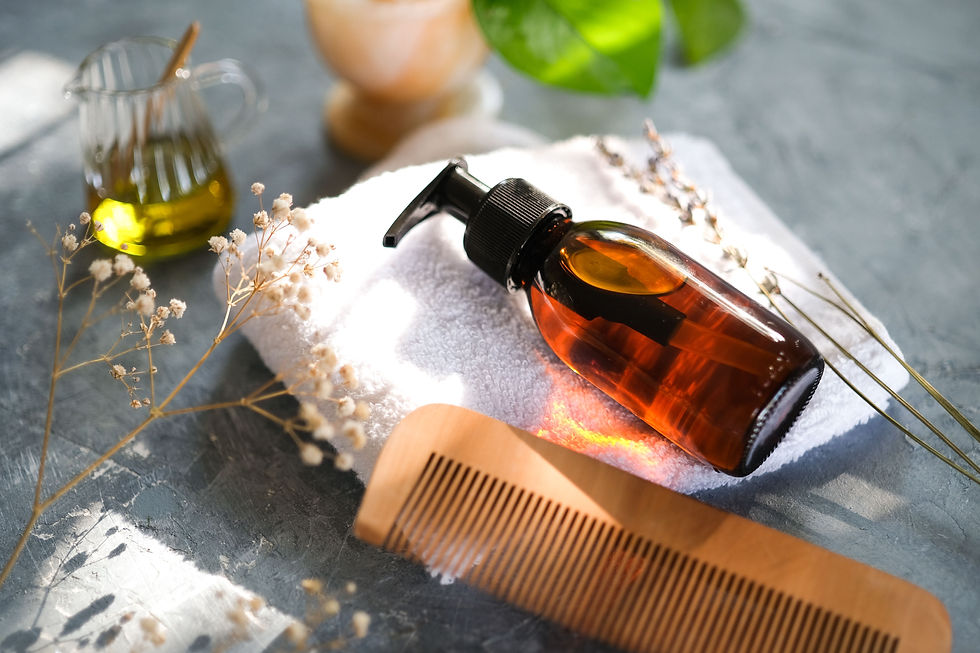 Flacon à pompe en verre ambré posé sur une serviette blanche, à côté d'un peigne en bois, sans marque visible.