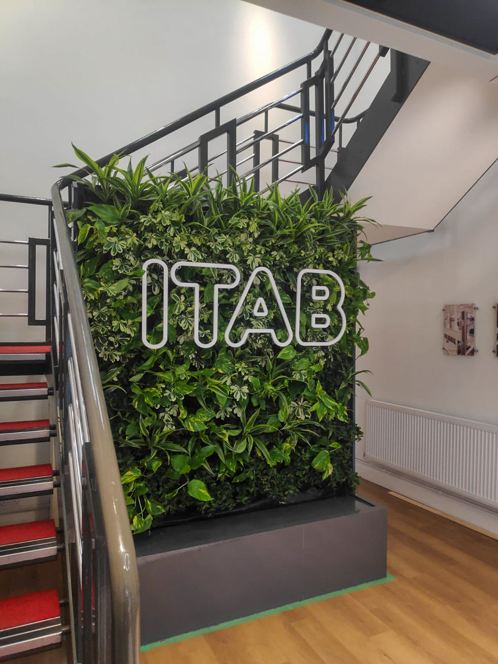 a living wall with company's logo and built-in irrigation next to a staircase