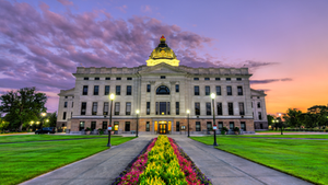 Capitol building, flanked by green lawns and flower beds, symbolizing Policy Design Household Access